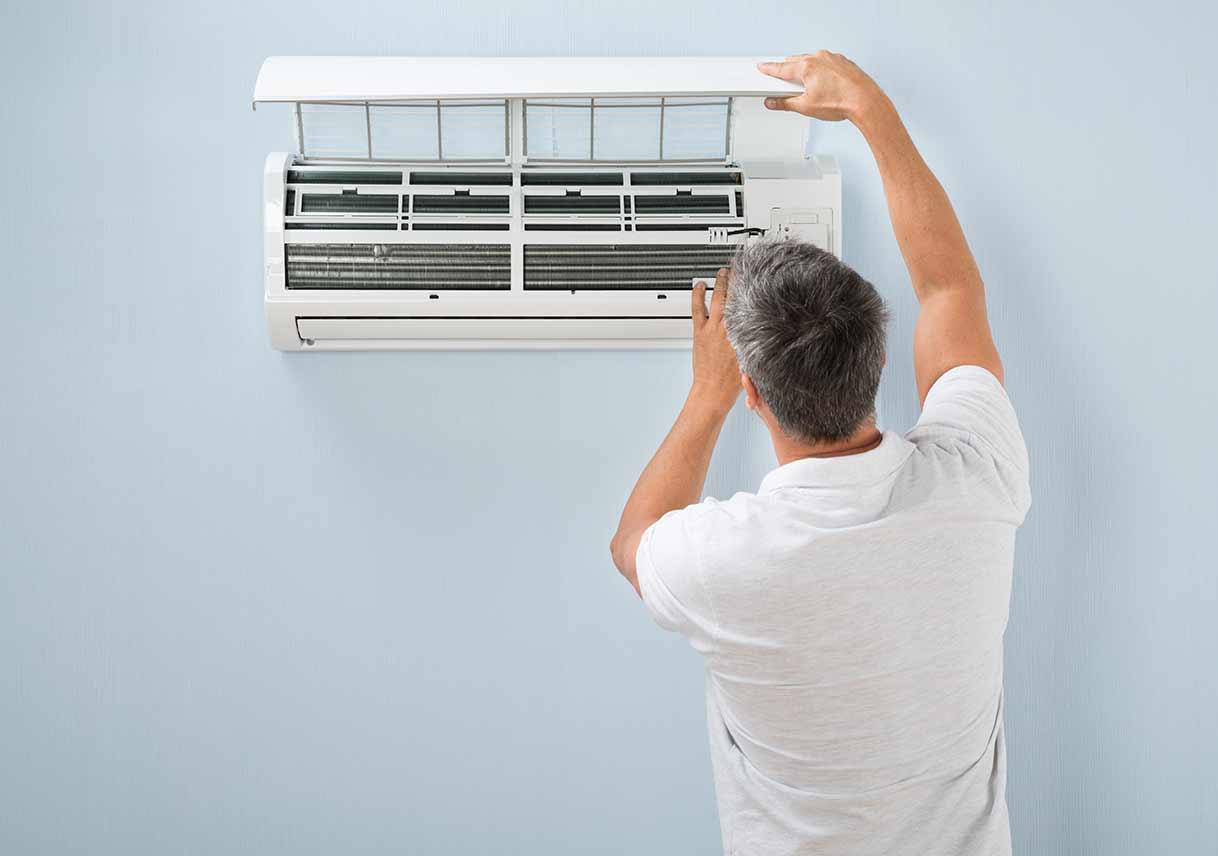 man-inspecting-air-conditioning-unit.jpg